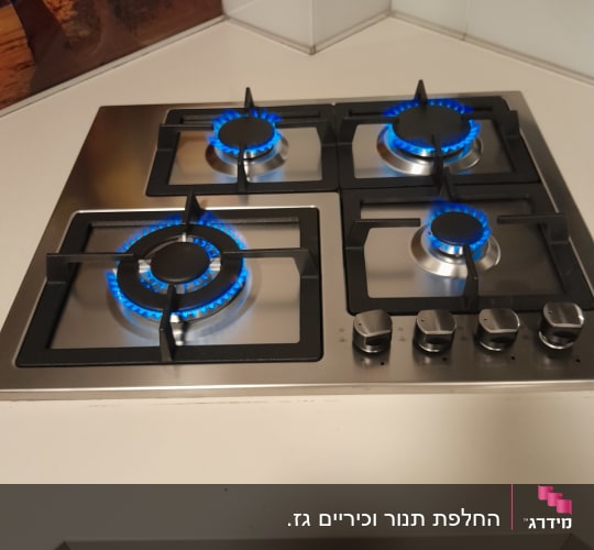 כיריים גז עם ארבעה מבערים דולקים